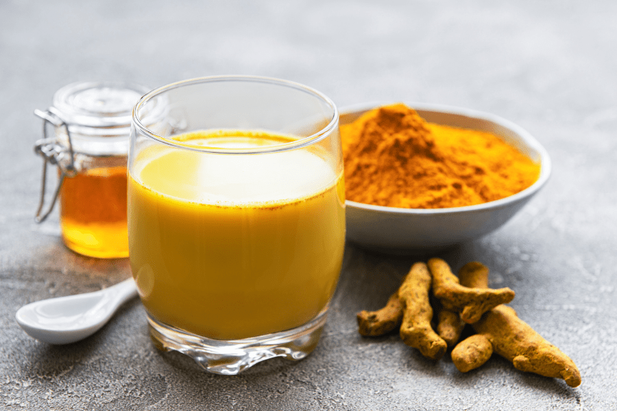 turmeric roots, powder and golden milk with honey