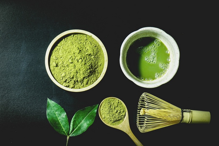 matcha tea powder, whisk and cup of tea